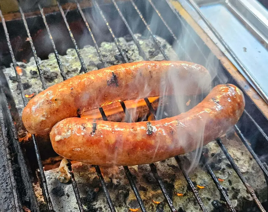 Greek sausages on the grill with visible flame