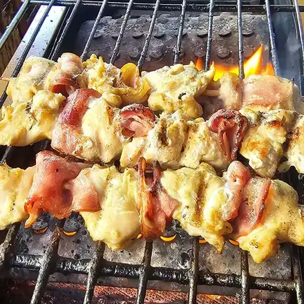 Souvlaki skewers grilling over the flame at Olympian